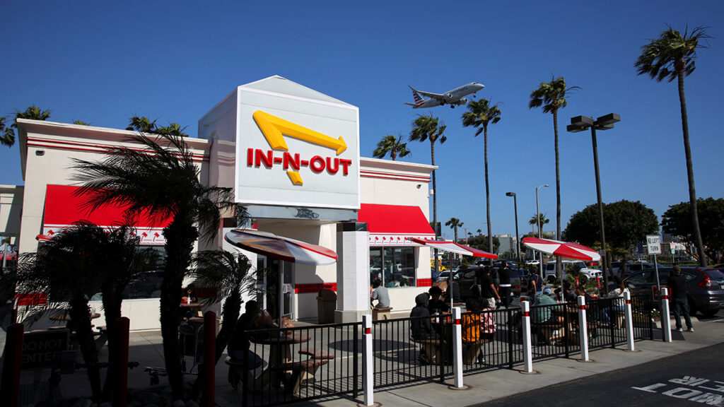 A plane flies over an In-N-Out Burger outlet in Los Angeles, California, U.S., May 7, 2025. REUTERS/Daniel Cole